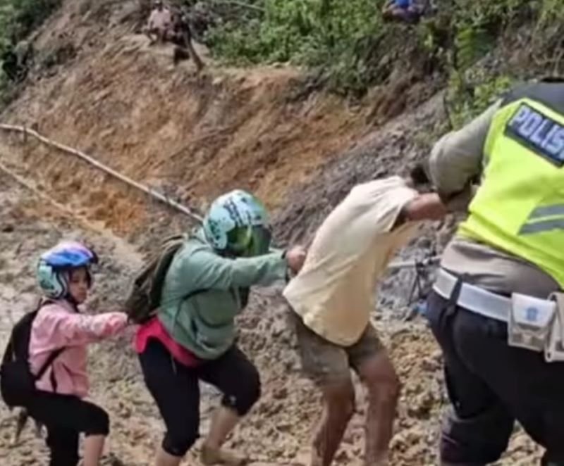 Salut! AKP Dahniel Berjibaku Gendong Bayi dan Tuntun Warga Lewati Jalan Batu Jomba