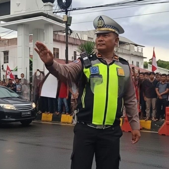 Gerimis Tak Surutkan Langkah, Polisi Lalu Lintas Tetap Tetap Tegak Jaga Ketertiban di Tengah Aksi