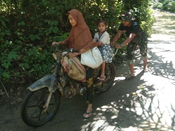 Aksi Humanis Satgas TMMD, Bantu Warga Dorong Motor Seberangi Genangan Air