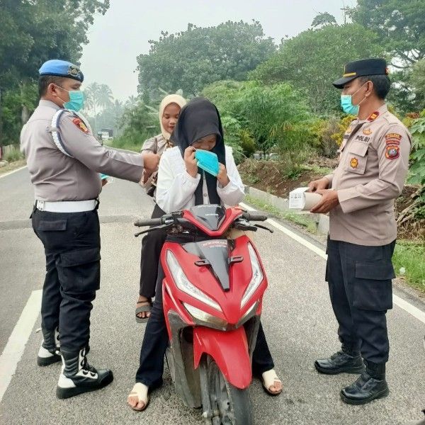 Cuaca Berkabut, Kapolsek Hutaimbaru Turun Langsung Bagikan Masker kepada Pengendara